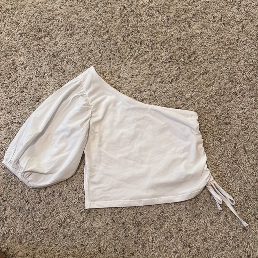 A chic off the shoulder white top, with one puffy sleeve. Size Xsmall.